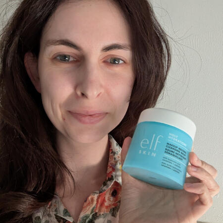 smiling women holds up elf skin care pot makeup remover